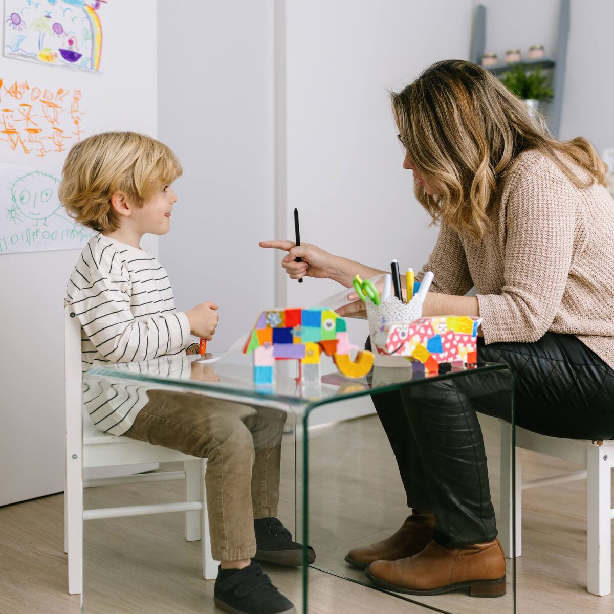 Ana Pastor trabajando con un niño en la mesa de la consulta